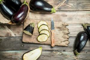 stukken van aubergine Aan een snijdend bord met een mes. foto