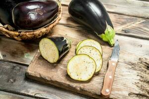 stukken van aubergine Aan een snijdend bord met een mes. foto