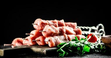 varkensvlees kebab rauw Aan een snijdend bord met tomaten en peterselie. foto