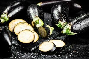 stukken van rijp aubergine Aan een steen bord. foto