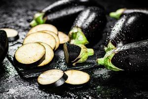 stukken van rijp aubergine Aan een steen bord. foto