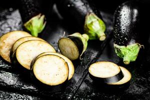 stukken van rijp aubergine Aan een steen bord. foto