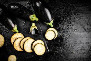 stukken van rijp aubergine Aan een steen bord. foto