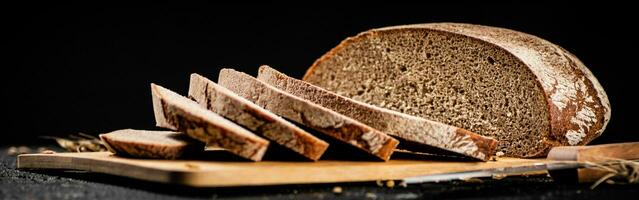 gesneden rogge brood Aan een snijdend bord. foto