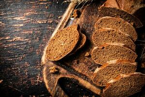 plakjes van geurig brood Aan een houten snijdend bord. foto