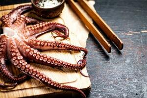 Octopus Aan een houten snijdend bord. foto
