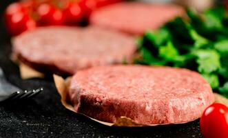 rauw hamburger met tomaten en peterselie. foto