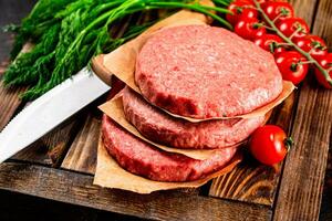 rauw hamburger Aan een houten dienblad met tomaten en dille. foto