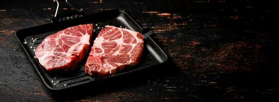 rauw varkensvlees steak Aan een rooster pan. foto