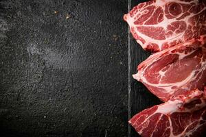 vers ongekookt varkensvlees steak Aan een steen bord. foto