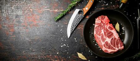 rauw varkensvlees steak in een frituren pan met baai bladeren en rozemarijn. foto