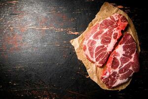 rauw varkensvlees steak Aan papier Aan de tafel. foto