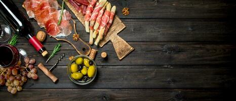 antipasto achtergrond.divers vlees voorafje met olijven, Jamon en rood wijn. foto