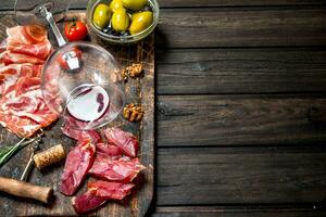 antipasto achtergrond. verschillend vlees snacks met rood wijn. foto