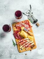 antipasto achtergrond. divers vlees en kaas snacks met rood wijn. foto