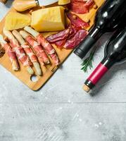 antipasto achtergrond. divers vlees en kaas snacks met rood wijn. foto
