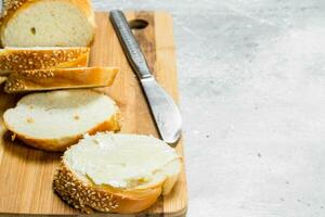 ontbijt. vers brood en boter Aan een houten bord. foto