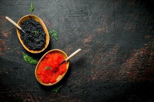 zwart en rood kaviaar in kommen met lepels en dille. foto