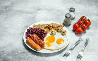 Engels ontbijt. gebakken eieren met worstjes, spek en bonen. foto