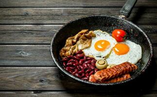 traditioneel Engels ontbijt met gebakken eieren, worstjes en bonen. foto