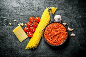 bolognese saus in pan met droog pasta, kruiden en parmezaan. foto