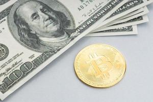 bitcoin-munt en een stapel Amerikaanse dollarbankbiljetten foto