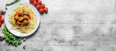 spaghetti en vlees ballen met peterselie en tomaten. foto