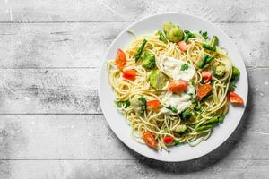 pasta met groenten en saus Aan een bord. foto