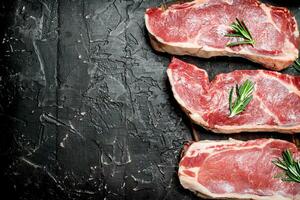 rauw rundvlees steaks met geurig rozemarijn. foto