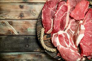 rauw vlees. rundvlees en varkensvlees steaks Aan de bord. foto