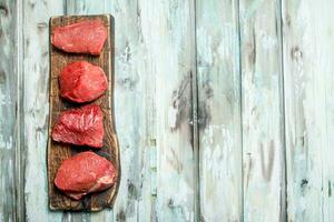 rauw vlees. stukken van rundvlees Aan de snijdend bord . foto