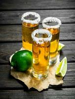 tequila in een schot glas Aan papier met limoen. foto