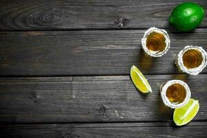 tequila in een schot glas van zout en limoen. foto