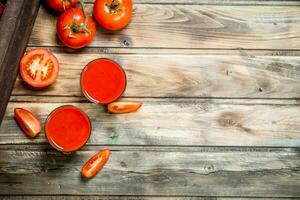 tomaat sap in een glas en tomaat plakjes. foto