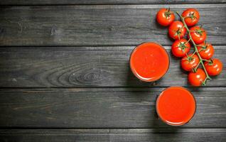 tomaat sap in een glas en een Afdeling van rijp tomaten. foto