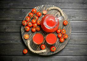 tomaat sap in een kruik Aan de dienblad met tomaten Aan een Afdeling. foto