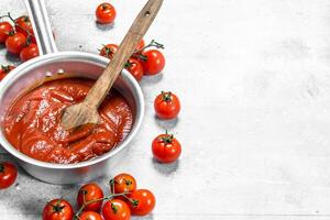 tomaat saus in een pot met vers tomaten. foto