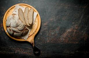 rogge brood Aan een ronde snijdend bord. foto