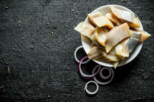 gesneden filet van gezouten haring met ui ringen. foto