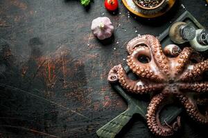 Octopus Aan een snijdend bord met knoflook en specerijen. foto