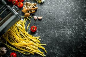 machine voor Koken eigengemaakt pasta met tomaten en champignons. foto