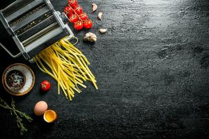 machine voor Koken eigengemaakt pasta met knoflook, tomaten en ei. foto