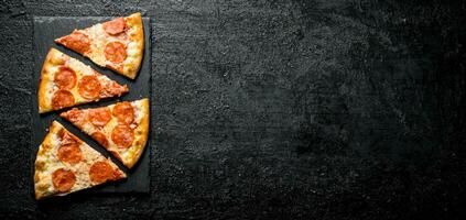 plakjes van peperoni pizza met worstjes en kaas. foto