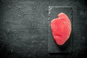 rauw tonijn steak Aan een steen bord. foto