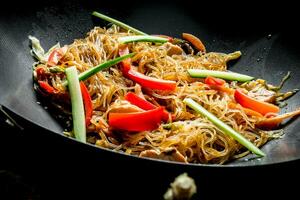 Chinese wokken. Koken Aziatisch funchoza met kip en groenten in een frituren pan wokken. foto