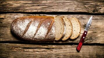 gesneden rogge brood met een mes. foto