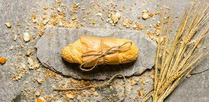 ciabatta verpakt in papier met kruimels Aan een steen stellage. foto