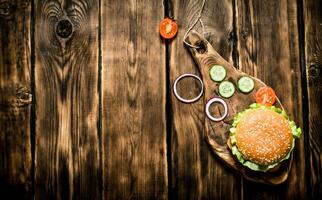 Hamburger met tomaten, uien en vlees Aan de bord. foto