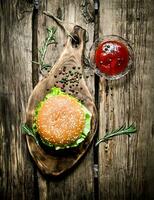 smakelijk Hamburger met saus Aan een houten bord. foto