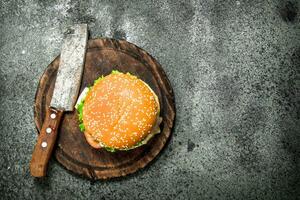 hamburger van vers rundvlees met een mes Aan de bord. foto